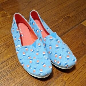 Toms Light Blue Canvas Slip-Ons with Bomb Pop Pattern